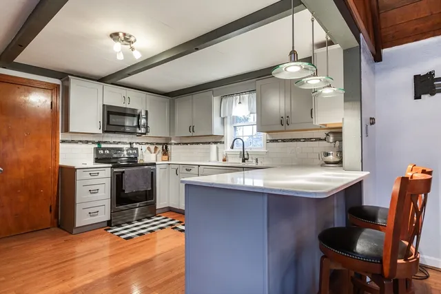 a kitchen with kitchen island a sink counter top space appliances and cabinets