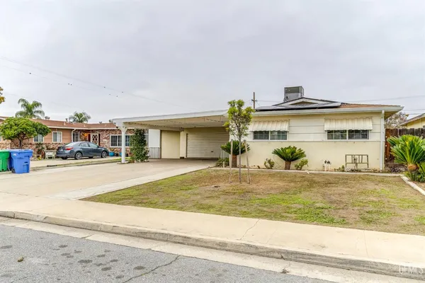 a front view of a house with a yard and large window