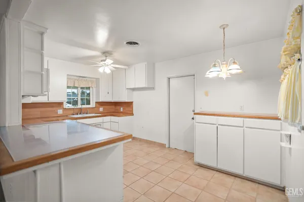 a kitchen with kitchen island white cabinets and chandelier