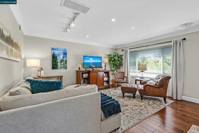 a living room with furniture and a wooden floor