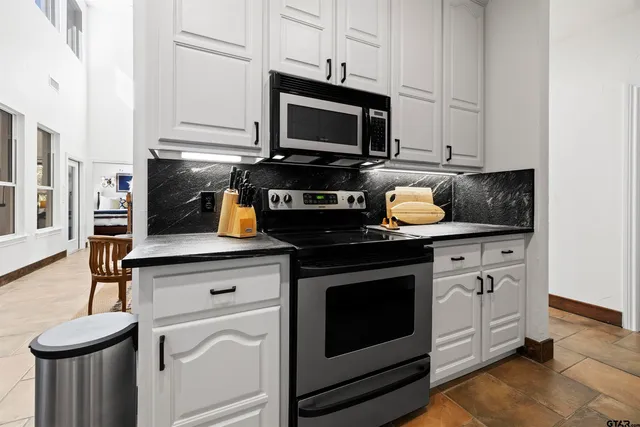 a kitchen with stainless steel appliances granite countertop a stove a microwave and oven