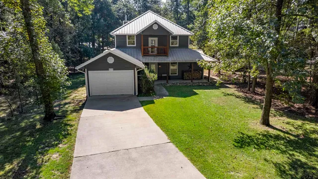 a front view of a house with yard and green space