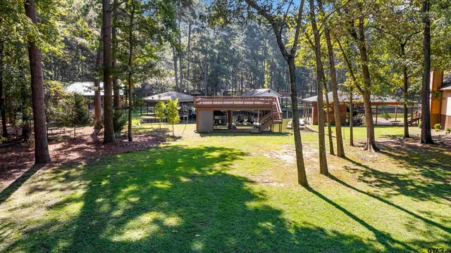 an aerial view of a house with swimming pool and large trees