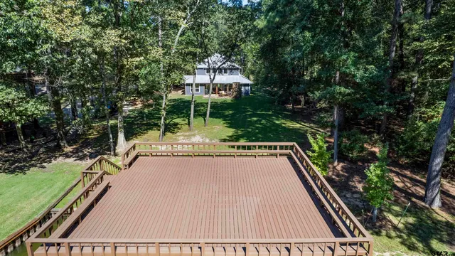 a view of a chairs and table in the patio next to a yard
