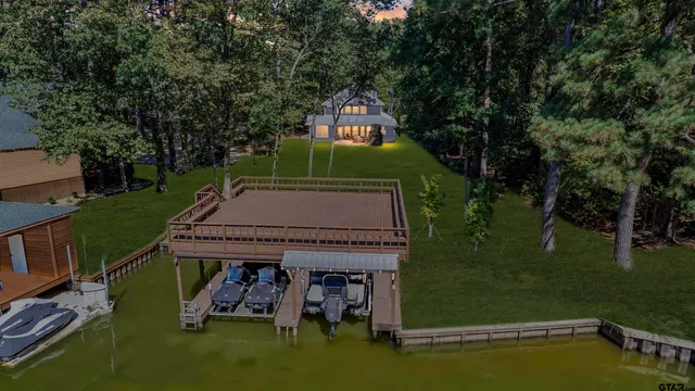 an aerial view of a house with a yard and lake view