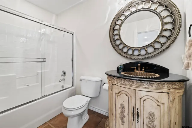 a bathroom with a toilet a sink and a mirror