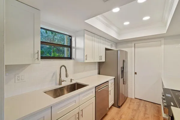 a kitchen with stainless steel appliances a refrigerator sink and cabinets