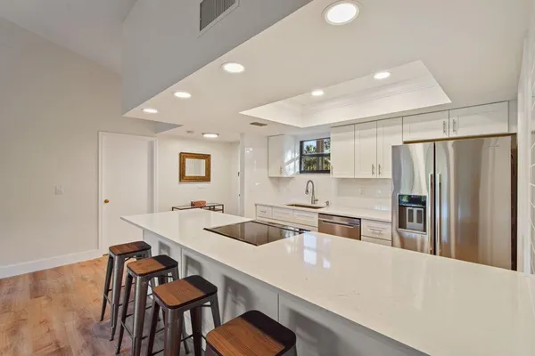 a kitchen with stainless steel appliances granite countertop a sink refrigerator and cabinets