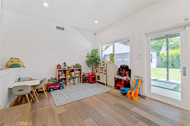 a children room with furniture and a wooden floor
