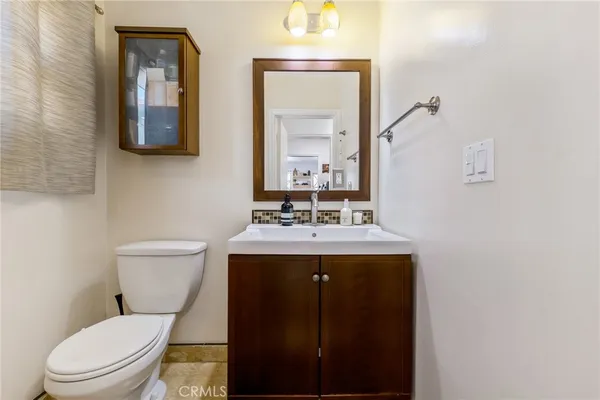 a bathroom with a toilet sink vanity and mirror