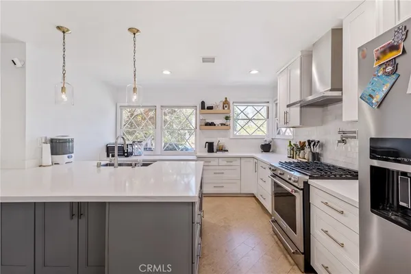 a kitchen with appliances a sink and cabinets