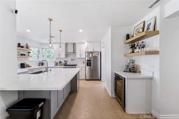 a kitchen with kitchen island a sink stove and refrigerator