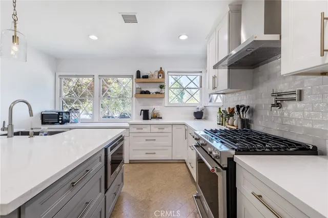 a kitchen with stainless steel appliances a sink stove and cabinets