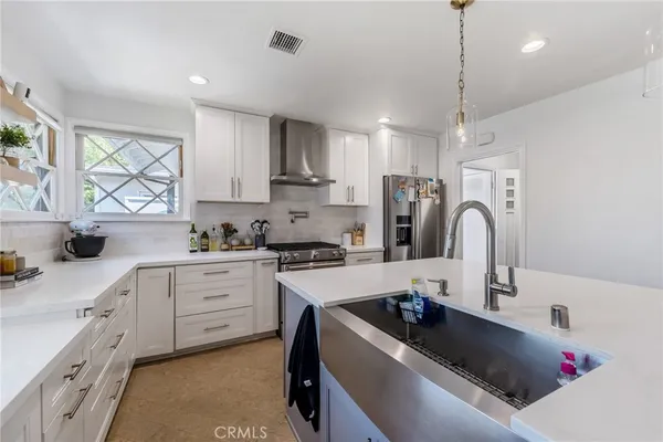 a kitchen with kitchen island white cabinets a sink a stove and a window