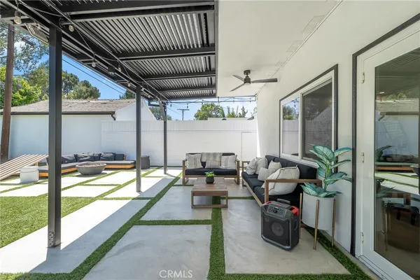 a living room with patio furniture and a floor to ceiling window