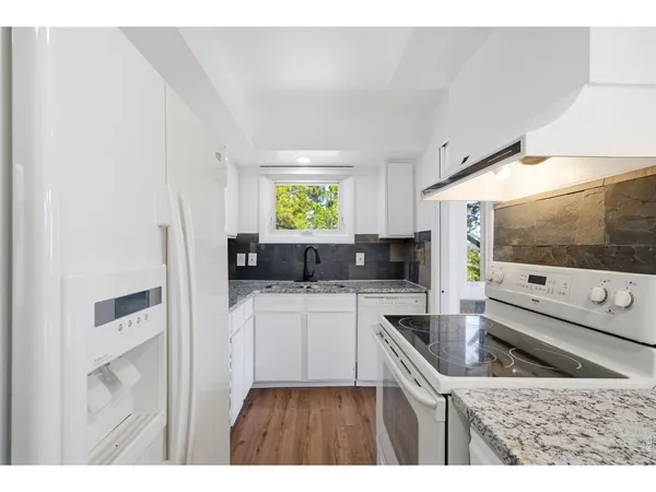 a kitchen with stainless steel appliances a sink a stove a refrigerator a sink a counter top space and cabinets