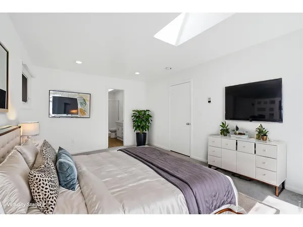 a bedroom with a bed and a flat screen tv