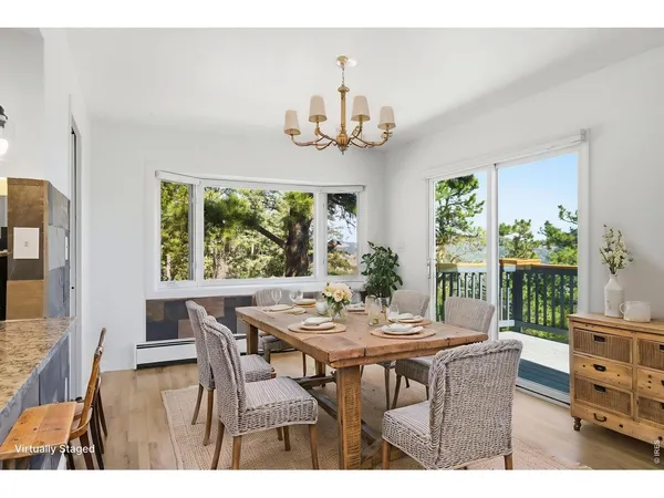 a view of a dining room with furniture a chandelier and wooden floor