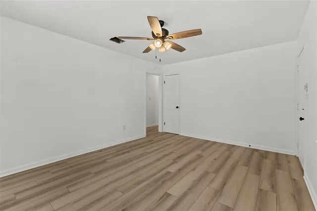 a view of room with wooden floor and ceiling fan