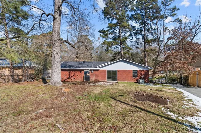a front view of a house with a yard and large trees