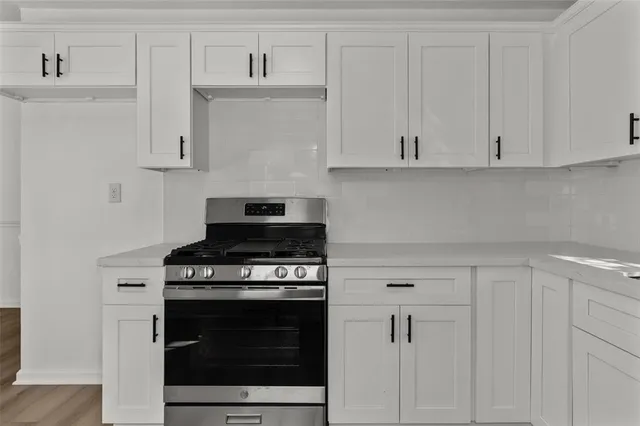 a kitchen with white cabinets and appliances
