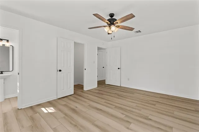 a view of a livingroom with wooden floor and a ceiling fan