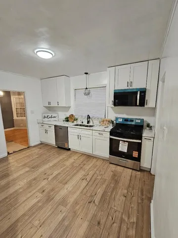 a kitchen with stainless steel appliances a stove sink and cabinets