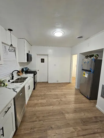 a large kitchen with a stove a refrigerator and a sink