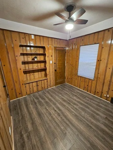 a view of empty room with a ceiling fan and wooden floor
