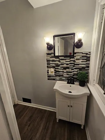 a bathroom with a sink a light fixture and a mirror