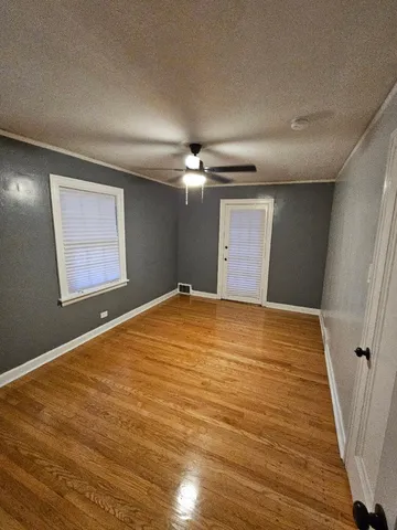 a view of a big room with wooden floor and windows