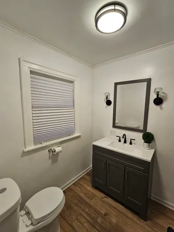 a bathroom with a toilet sink a mirror and vanity