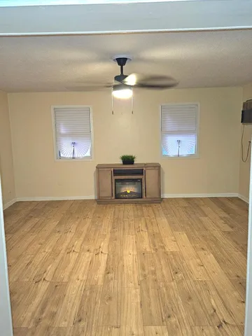 a view of empty room with wooden floor