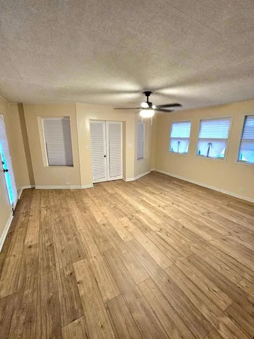 an empty room with wooden floor and windows
