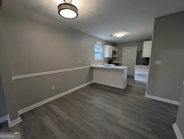 a kitchen with cabinets and wooden floor