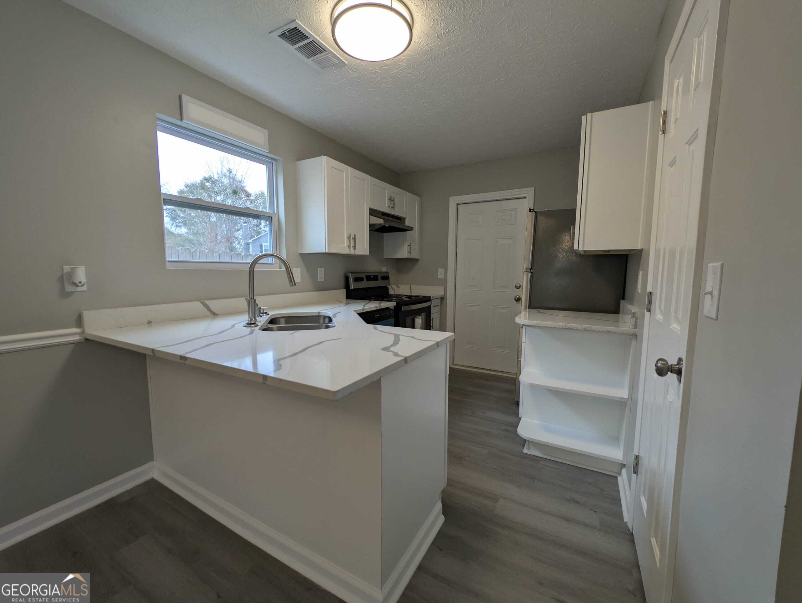 128 Crystal Brook Griffin, GA 30223 - Photo 6 of 25 a kitchen with a sink cabinets and wooden floor