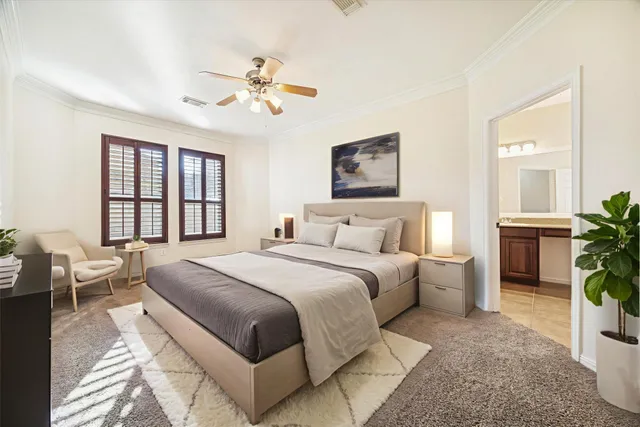 a spacious bedroom with a large bed and a chandelier