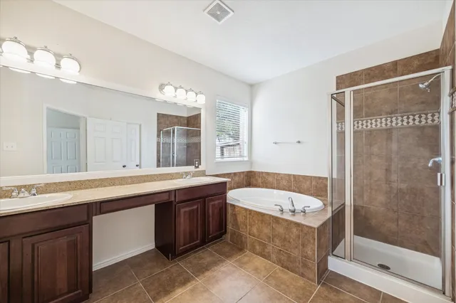 a bathroom with a tub a sink and mirror
