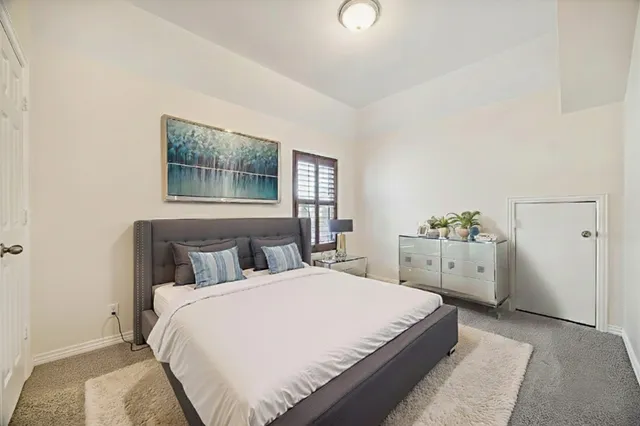 a bedroom with a white bed and white walls