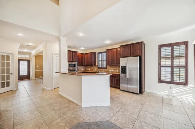 a kitchen with stainless steel appliances granite countertop a refrigerator and a stove top oven