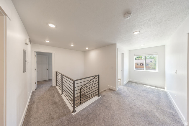 4991 South 475 West Washington Terrace, UT 84405 - Photo 20 of 31 Hallway. Flex space to the right by window. Light grey carpet. Natural light. Recessed lighting.