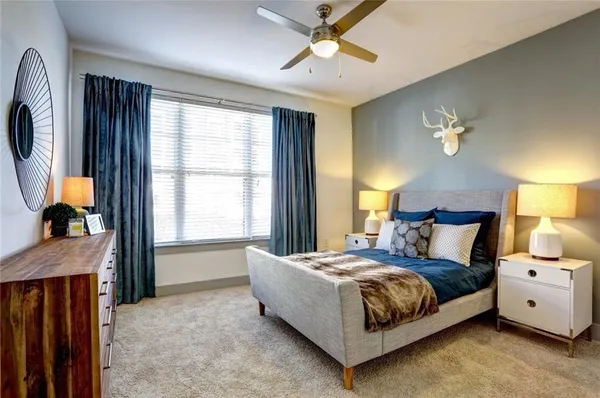 a bedroom with a large bed and a chandelier
