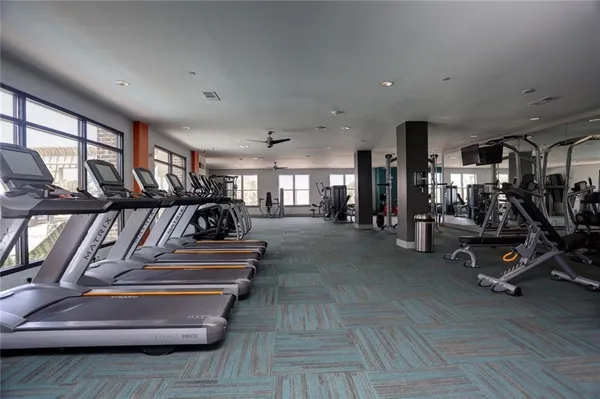 a view of gym equipment and living room with furniture