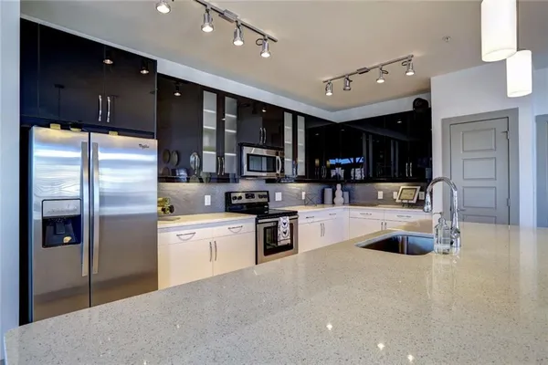 a kitchen with stainless steel appliances granite countertop a refrigerator and a sink