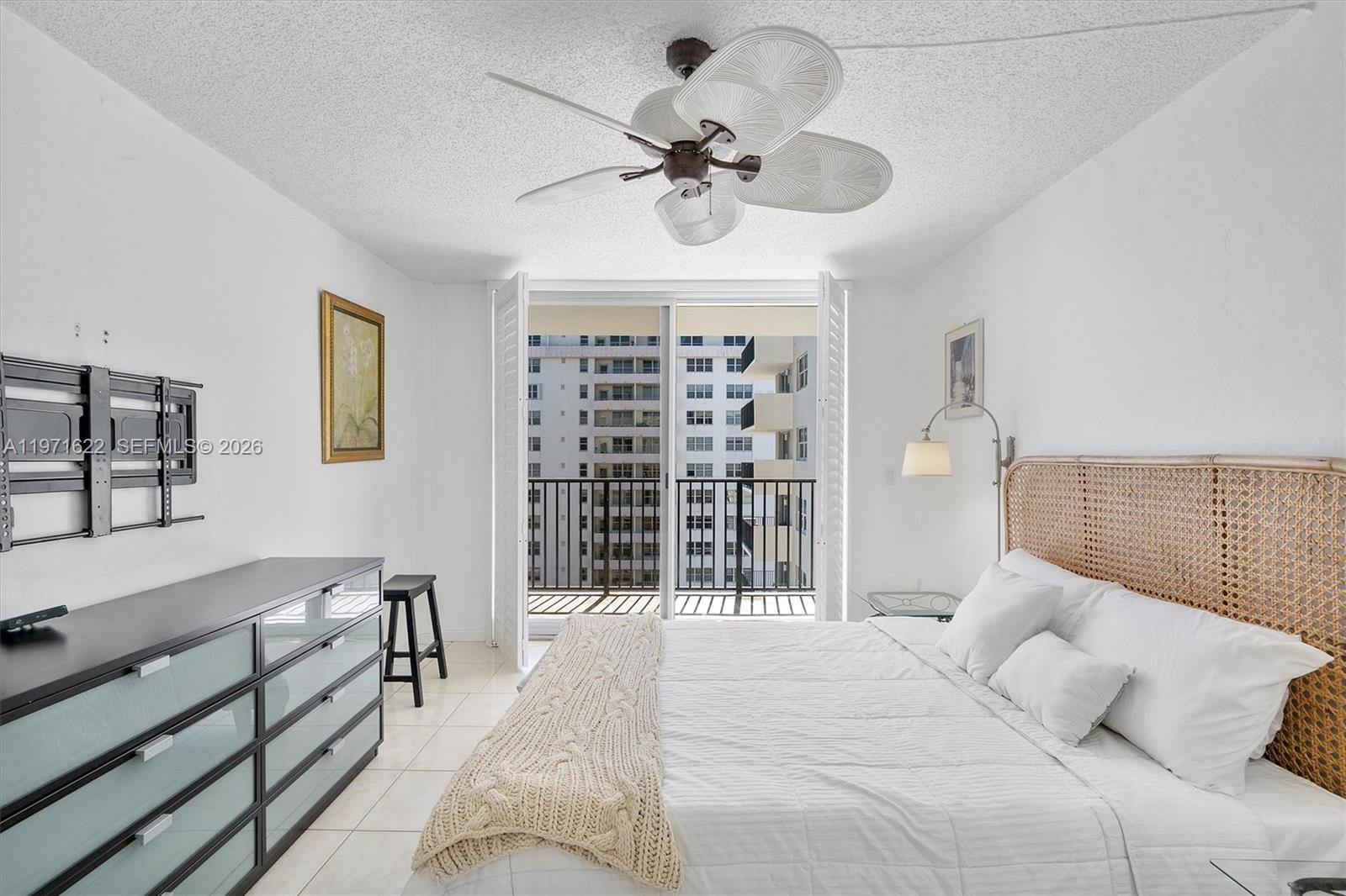9273 Collins Avenue, Unit 901 Surfside, FL 33154 - Photo 11 of 24 a bedroom with a large bed and a chandelier
