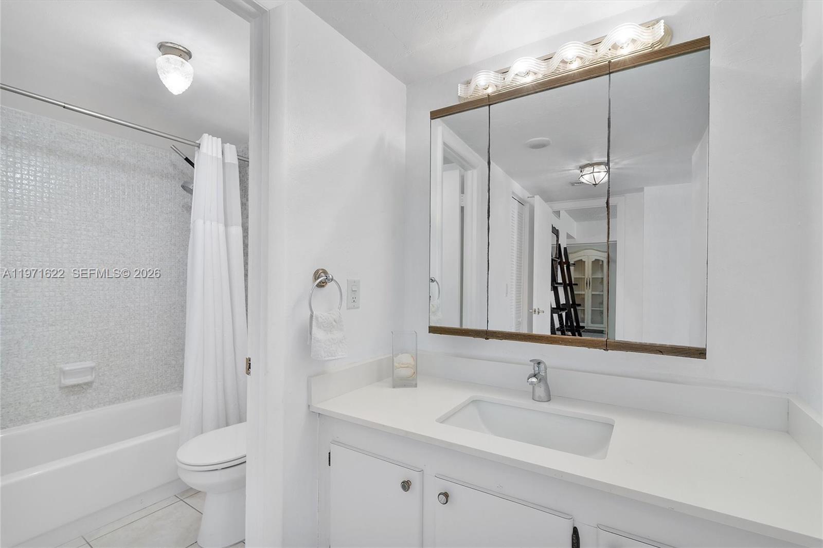 9273 Collins Avenue, Unit 901 Surfside, FL 33154 - Photo 12 of 24 a bathroom with a sink a toilet a mirror and shower