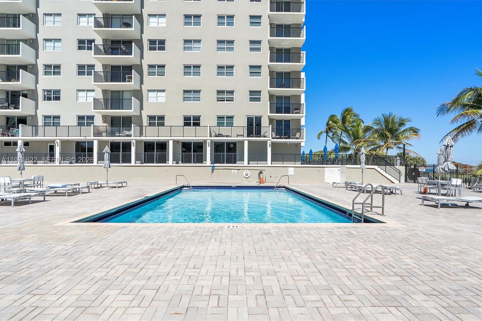 9273 Collins Avenue, Unit 901 Surfside, FL 33154 - Photo 17 of 24 a swimming pool with outdoor seating
