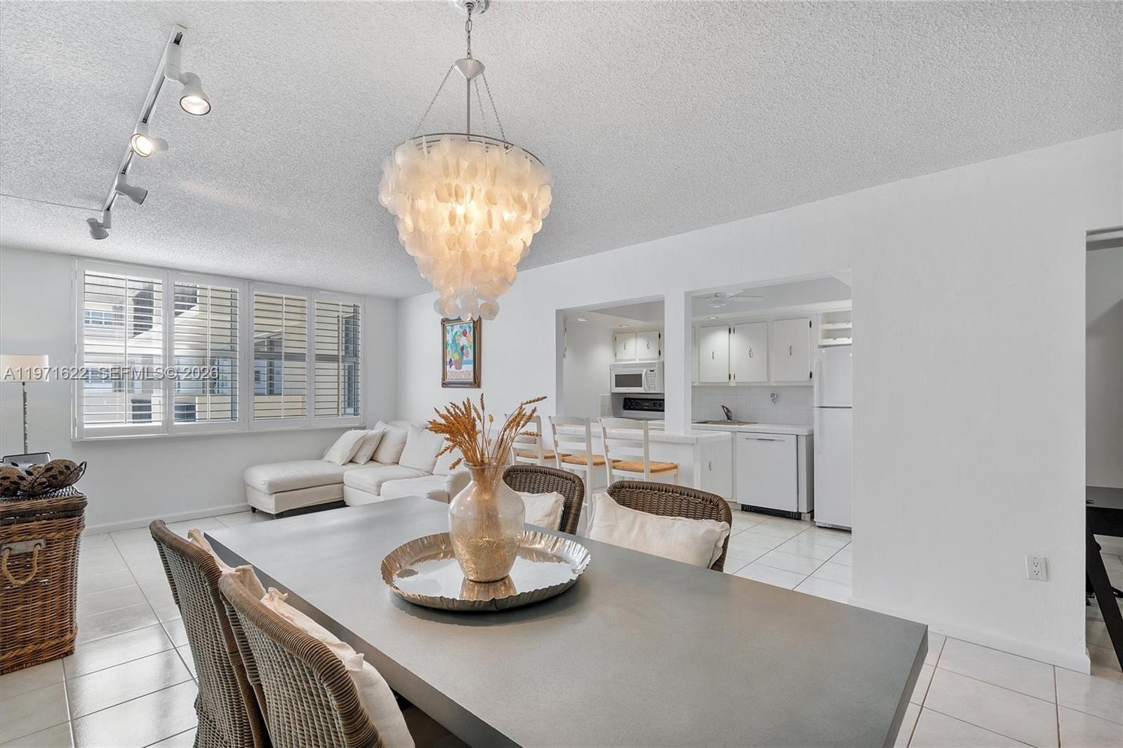 9273 Collins Avenue, Unit 901 Surfside, FL 33154 - Photo 7 of 24 a view of a dining room with furniture wooden floor and chandelier