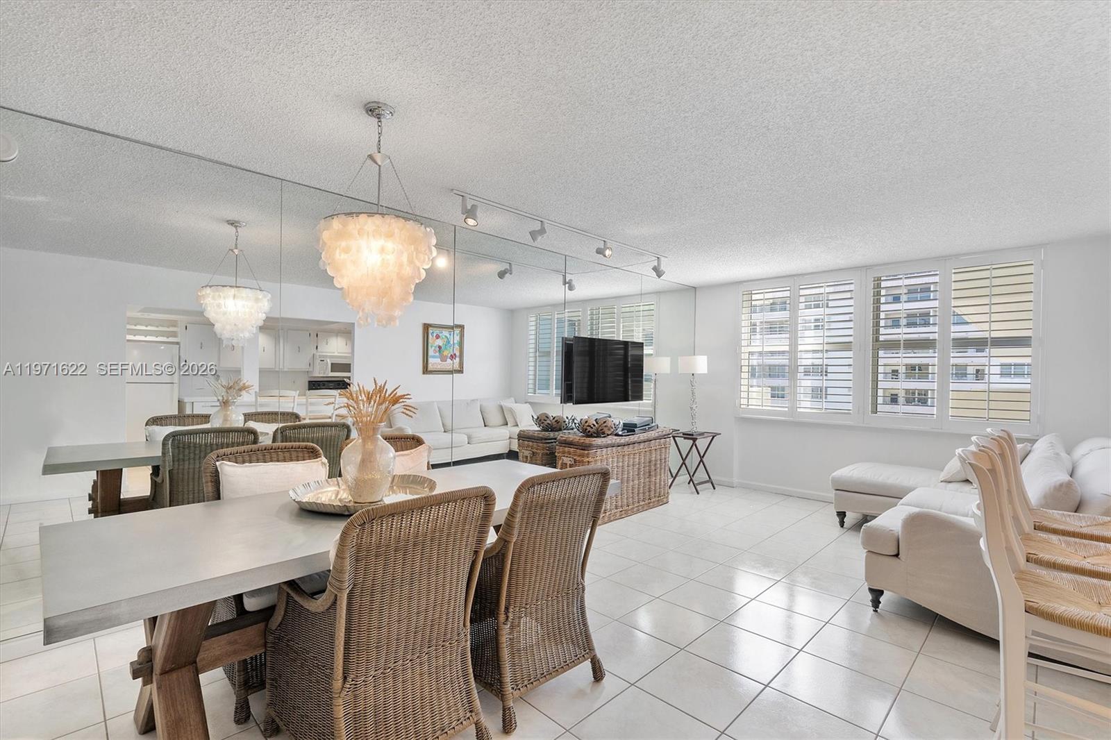 9273 Collins Avenue, Unit 901 Surfside, FL 33154 - Photo 9 of 24 a living room with lots of furniture and a flat screen tv