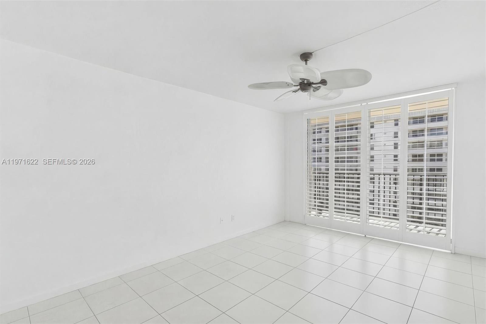 9273 Collins Avenue, Unit 901 Surfside, FL 33154 - Photo 10 of 24 an empty room with windows and fan